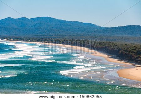 Aerial view of Australian coastal sand beach with mountains on the background. Nambucca Heads NSW Australia