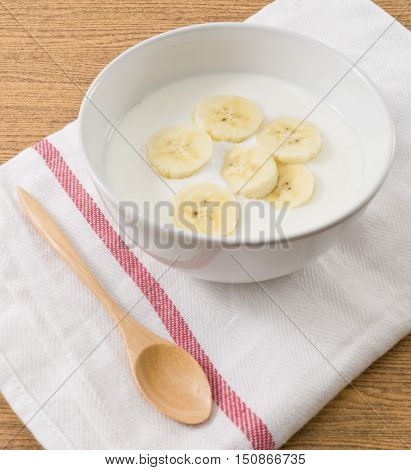 Bowl of Homemade Yoghurt Topping with Ripe Banana Nutritionally Rich in Protein Calcium Riboflavin Vitamin B6 and Vitamin B12.