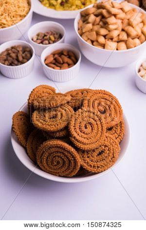 home made tasty Diwali food or Diwali snacks or Diwali sweets like rava laddu, chakli, sev,shankar pale and chivda or chiwada with dry fruits in white bowls, favourite indian diwali recipe