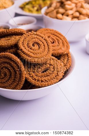 home made tasty Diwali food or Diwali snacks or Diwali sweets like rava laddu, chakli, sev,shankar pale and chivda or chiwada with dry fruits in white bowls, favourite indian diwali recipe