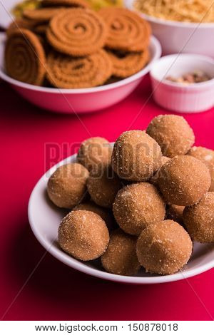 home made tasty Diwali food or Diwali snacks or Diwali sweets like rava laddu, chakli, sev,shankar pale and chivda or chiwada with dry fruits in white bowls, favourite indian diwali recipe
