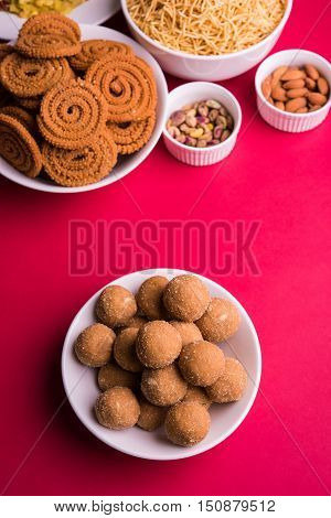 home made tasty Diwali food or Diwali snacks or Diwali sweets like rava laddu, chakli, sev,shankar pale and chivda or chiwada with dry fruits in white bowls, favourite indian diwali recipe
