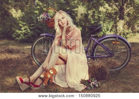 Dreaming woman with a bicycle she is holding in his hand a child's toy.