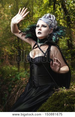 Gothic girl in black dress looking up.