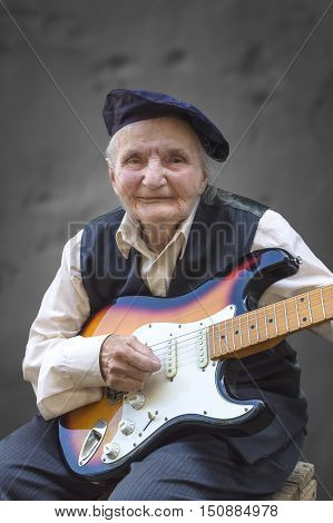 Elderly woman playing a guitar. Selective focus.