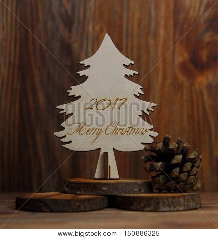 Christmas tree on a stub with the cone on a wooden background with an inscription of a Merry Christmas