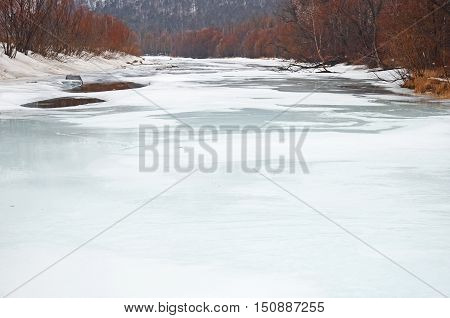 Icebound river on a cloudy spring day. Irkutsk Region, Russia