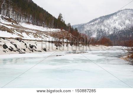 Icebound river on a cloudy spring day. Irkutsk Region, Russia