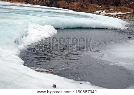 Icebound river on a cloudy spring day. Irkutsk Region, Russia