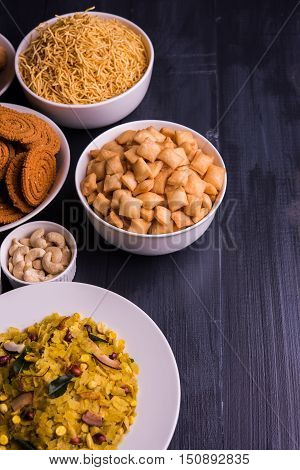 homemade tasty Diwali food or Diwali snacks or Diwali sweets like rava laddu, chakli, sev, shankar pale and chivda or chiwada with dry fruits in white bowls, favourite indian diwali recipe