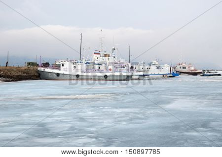 Ship And Fisher Boats On The Dock In Large Goloustnoye Village. Baikal Lake