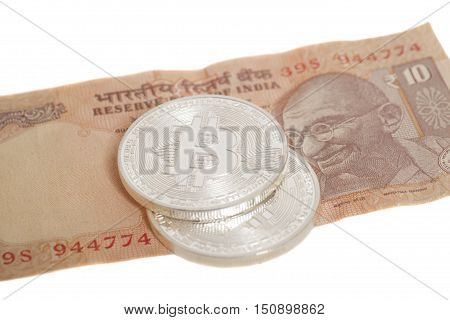 Silver bitcoin coins on Indian Ten Rupee isolated on white