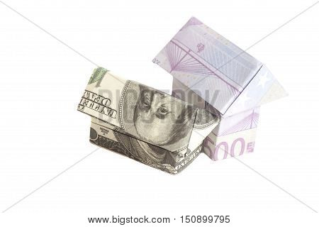 Origami house made of 500 euro and 100 dollar banknotes isolated on white background