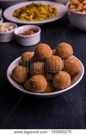 homemade tasty Diwali food or Diwali snacks or Diwali sweets like rava laddu, chakli, sev, shankar pale and chivda or chiwada with dry fruits in white bowls, favourite indian diwali recipe