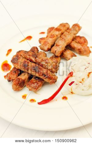 chevap or kebab- grilled meat sticks with chopped onions and pepper,Serbian national dish
