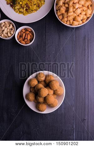 homemade tasty Diwali food or Diwali snacks or Diwali sweets like rava laddu, chakli, sev, shankar pale and chivda or chiwada with dry fruits in white bowls, favourite indian diwali recipe