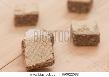 Wafers with chocolate on wooden background .