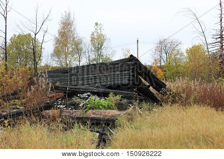 Destroyed burned out abandoned old house foundation ruins at the countryside village. Fire alarm notification system accident insurance protection concept.