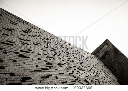 Restoration of an ancient wall made with a pattern of bricks leaving spaces between them