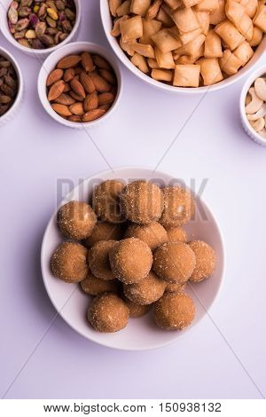 homemade tasty Diwali food or Diwali snacks or Diwali sweets like rava laddu, chakli, sev, shankar pale and chivda or chiwada with dry fruits in white bowls, favourite indian diwali recipe