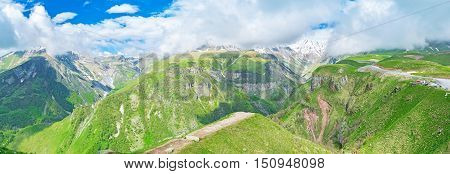 The view from the top of Gudauri (Cross) Pass on the peaks of Greater Caucasus Mountain Range covered with fluffy clouds Gudauri Georgia.