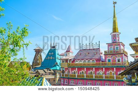 The colorful fairy tale mansion with golden spire rooster weathervane and painted facade serves as hotel and craft center in Izmailovsky Market the Russian style entertainment and trade center Moscow Russia.