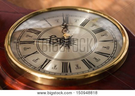 Antique clock with Roman numerals and a beautiful face. Watches are decorated with noble wood