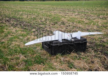 Small plane with propeller before starting on black box on background of green field