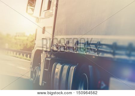 Fast Truck on the Highway Closeup Photo. Speeding Semi Truck