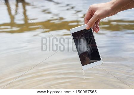 Hand holding a wet smartphone / Waterproof smartphone concept
