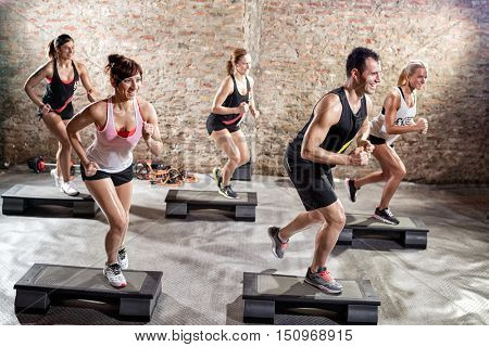 Group of fit people practicing on steeper, class of  stepping