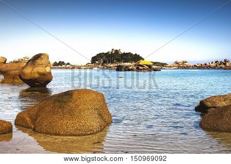 Ploumanach ock and bay beach in morning. Toned. Pink granite coast Perros Guirec Brittany France. Long exposure.