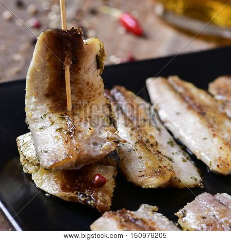 closeup of a plate with some spanish sardine fillets served as tapas, on a rustic wooden table