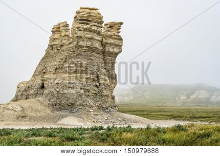 Castle Rock - limestone pillar landmark in prairie of western Kansas near Quinter (Gove County) , foggy summer morning