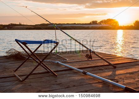 fishing utensils on a wooden platform on the pond