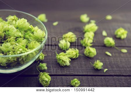Close Up Of Green Ripe Hop Cones In A Glass Bowl Over Dark Rustic Wooden Background. Beer Production