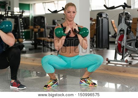 Couple Doing Heavy Weight Exercise With Kettle-bell