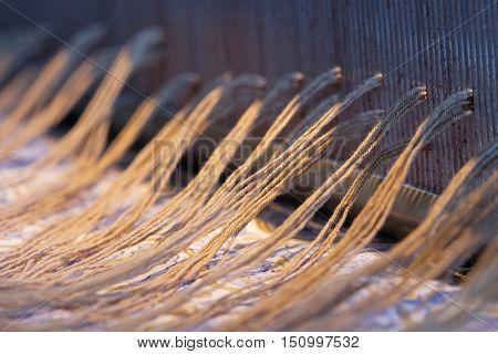 Preparing a loom before starting to make carpets. Warm light and short depth of focus