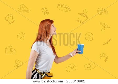 More Coffee. Cheerful Friendly Student Coming To A Cafe With A Blue Glass And Smiling While Asking F