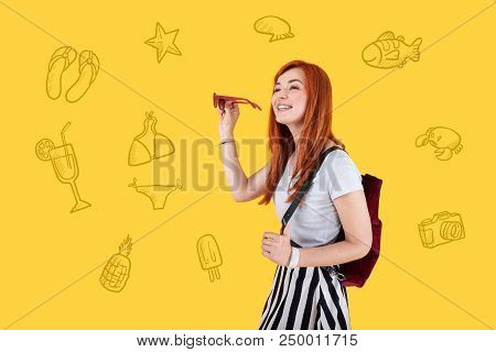 Sea Journey. Cheerful Young Person Smiling And Holding New Sunglasses While Walking At The Seaside