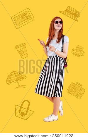 Listening To Music. Cheerful Young Traveler Smiling And Listening To Music In Her Smartphone While G