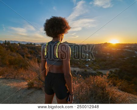 african american woman watching sunset while resting after hike at runyon canyon