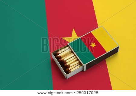 Cameroon Flag  Is Shown In An Open Matchbox, Which Is Filled With Matches And Lies On A Large Flag.