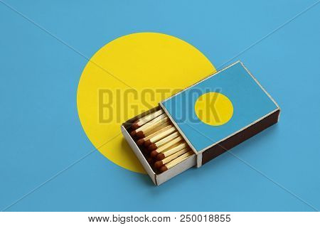 Palau Flag  Is Shown In An Open Matchbox, Which Is Filled With Matches And Lies On A Large Flag.