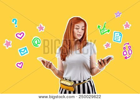 Two Gadgets. Thoughtful Beautiful Student Standing Alone With Two Smartphones In Her Hands And Looki