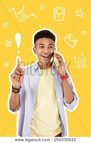 Great Idea. Positive Clever Student Talking On The Phone And Sharing His Brilliant Idea With A Frien