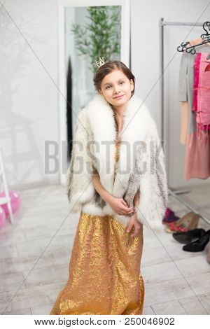 Sweet Girl Wearing Princess Like Clothing. Pretty Little Lady Dressed Up In Golden Dress And Furry C