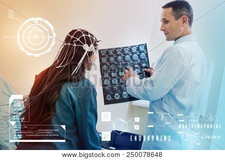 Analyzing Eeg Results. Kind Attentive Doctor Kindly Looking At His Young Long Haired Patient While T