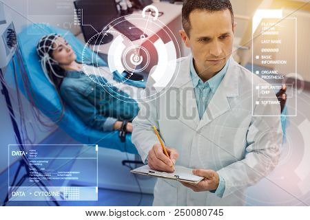Serious Doctor. Attentive Qualified Doctor Making Necessary Notes While A Young Woman Underdoing Ele