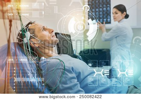 Man Undergoing Eeg. Serious Calm Man Looking At The Ceiling And Keeping Silent While Undergoing Elec